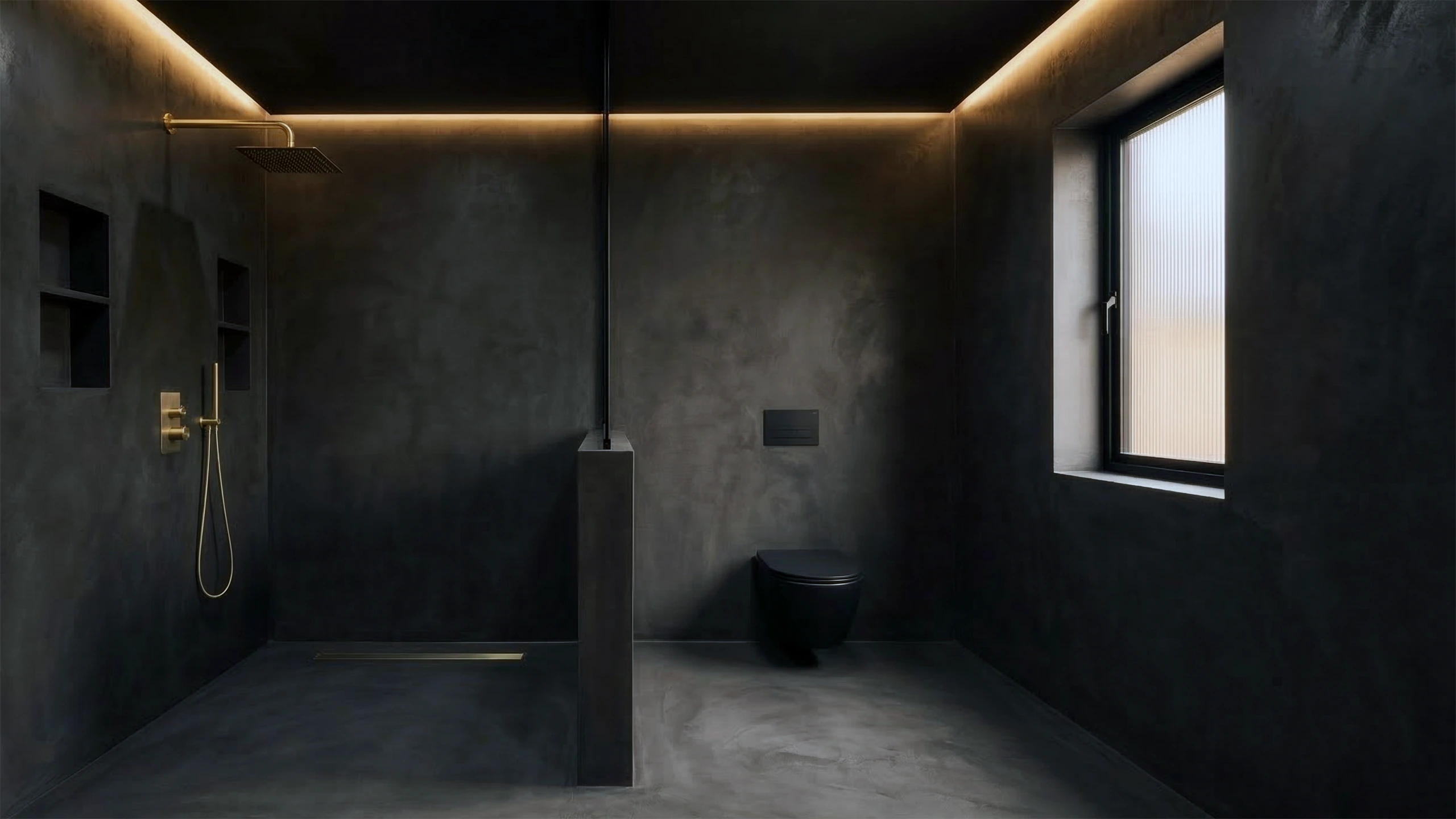 Dark microcement bathroom interior showing seamless floor-to-wall finish with gold fixtures and linear drain