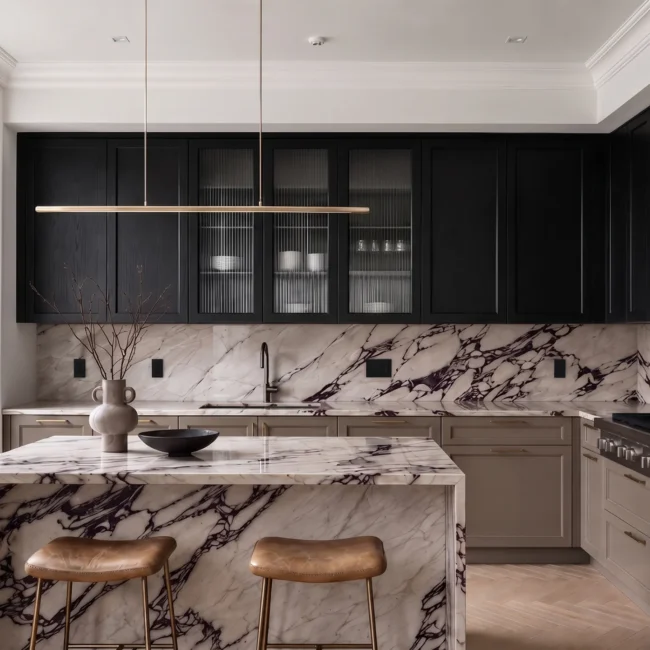 High-end NYC kitchen renovation featuring matte black upper cabinets, a dramatic Calacatta Viola marble waterfall island, matching marble backsplash, and leather bar stools with a Manhattan street view